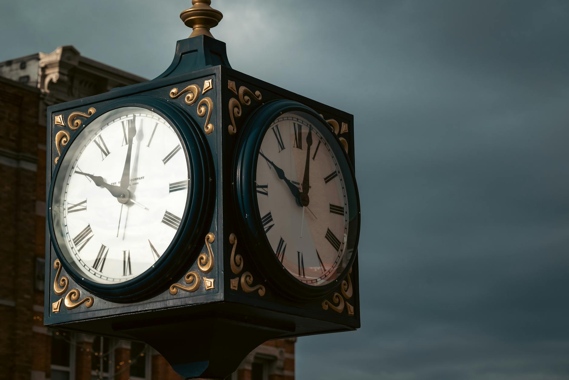 Elevate spaces with a classic outdoor clock displaying Roman numerals against a moody sky backdrop.